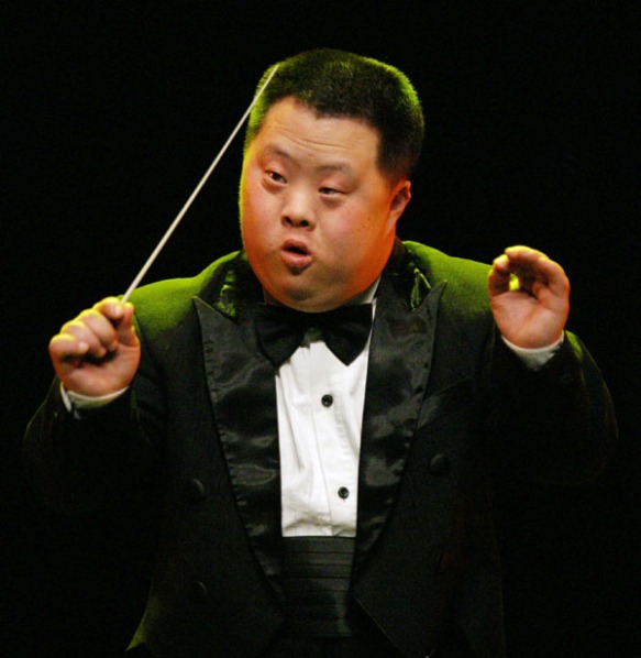 Down Syndrome performer Hu Yizhou from the China Disabled Peoples Performing Art Troupe conducts at a rehearsal for a concert in Seoul March 5, 2004. The group which consists of deaf, blind, and handicapped performers took to the stage at a road show in South Korea on Friday. REUTERS/You Sung-Ho KKH/SH